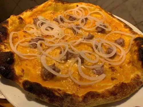 Ma il fiore all'occhiello de L'Osteria della Piazza sono le pizze, realizzate con un impasto speciale che grazie a una lievitazione che va dalle 45 alle 50 ore risulta leggero e digeribile. Le pizze in menù sono una trentina ed hanno nomi fantasiosi, si va dalla semplice Italia (la margherita) a O'Puorco con salsiccia e scamorza, passando per A'Poposcia con gorgonzola, prosciutto cotto, salsiccia, peperoni arrostiti, capperi, aglio e origano. I prezzi per le pizze vanno dai 6 ai 10 euro.